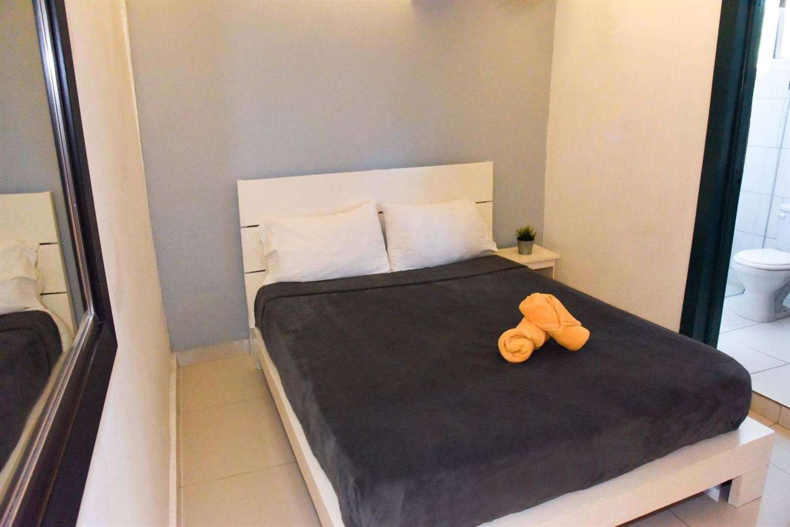 Gato Colonial: double room with dark bedding and orange towels