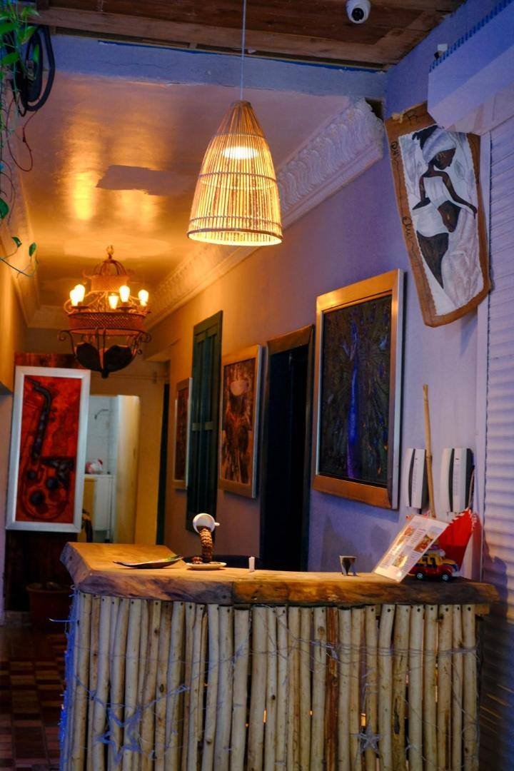 Gato Colonial: reception desk made of wooden branches, artwork and a hanging lamp